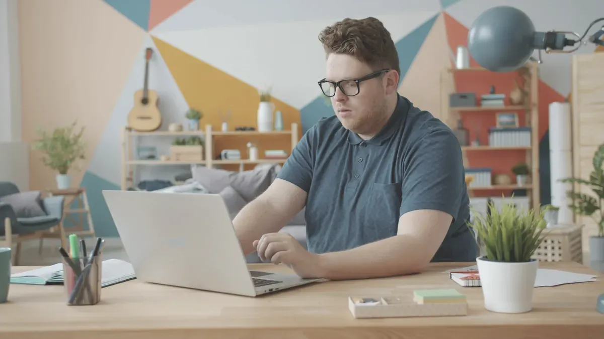 Person som arbetar vid en laptop vid ett skrivbord