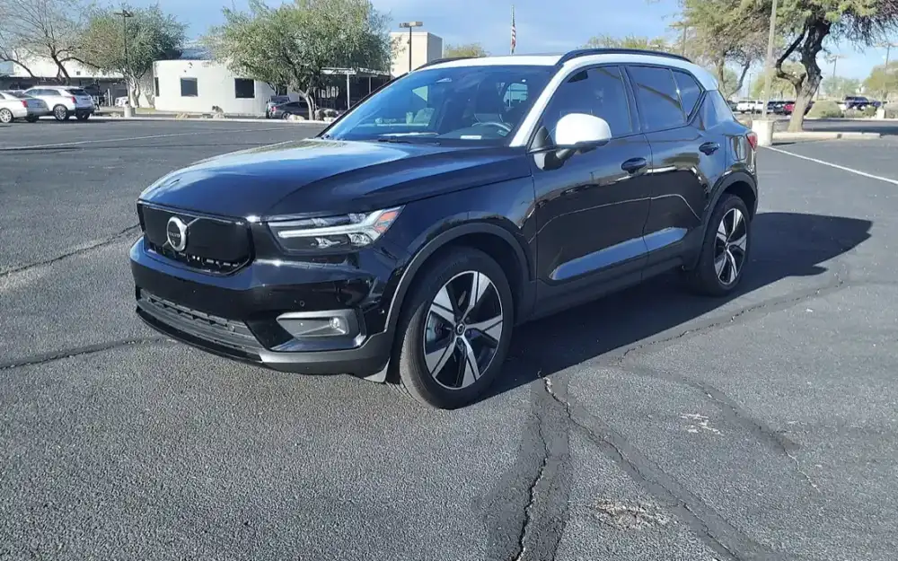 Svart Volvo XC40 Recharge fotograferad snett framifrån på en parkeringsplats